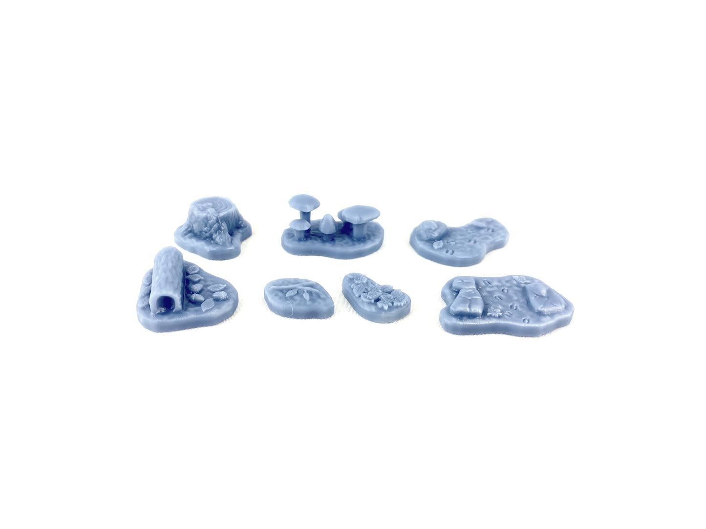 Alle sieben Waldboden-Bases aus dem Scatter-Set unbemalt, zeigt die detaillierten Resin-Modelle mit Ästen, Blättern, Pilzen und Bodenstrukturen, bereit zum Bemalen und für Tabletop-Spiele.