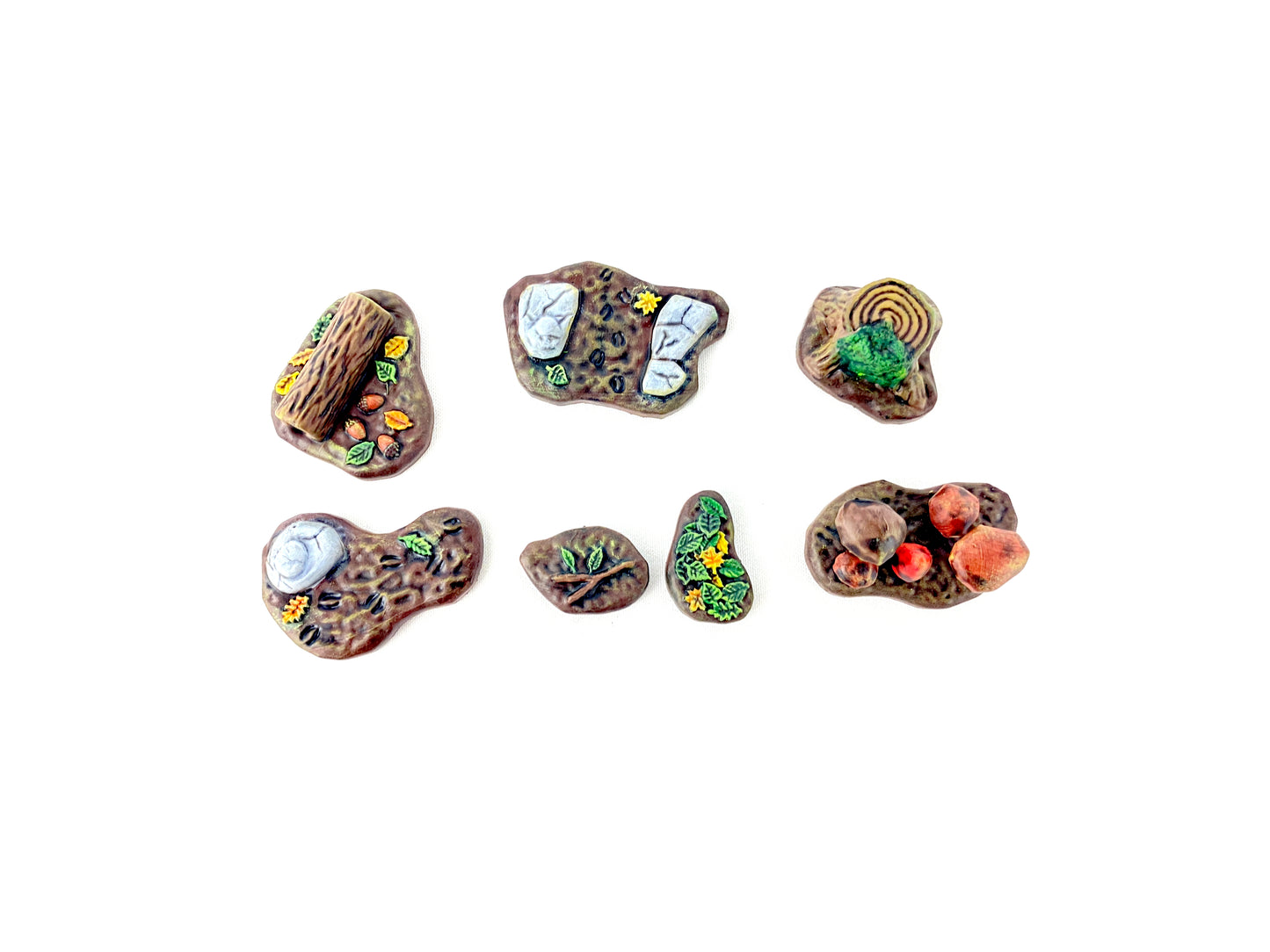 Alle sieben bemalten Waldboden-Bases aus dem Waldboden-Scatter-Set von oben fotografiert, zeigt die detaillierten Äste, Blätter und Pilze für atmosphärisches Tabletop-Gelände.