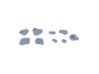 Unbemaltes Sci-Fi Scatter Terrain Set: Acht Resin-Bases im Rohzustand mit Details wie Benzinkanister, Werkzeuge, Schutt und Trümmer im 28mm Maßstab.