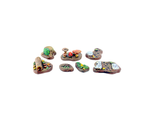 „Alle sieben Waldboden-Bases aus dem Waldboden-Scatter-Set bemalt, mit detaillierten Ästen, Blättern, Pilzen und Bodenstrukturen, ideal für Tabletop- und Pen-&-Paper-Szenen.“